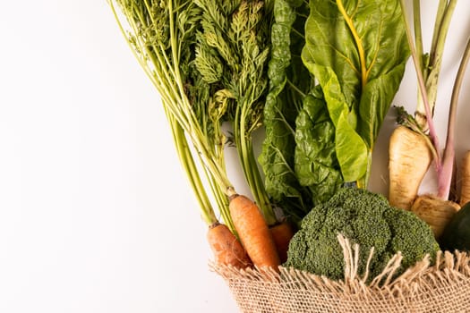 Overhead view of fresh organic vegetables with burlap on white background, copy space. unaltered, food, healthy eating, organic.