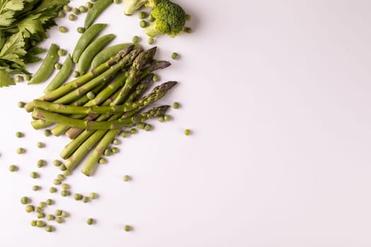 Overhead view of fresh asparagus and broccoli by copy space on white background. unaltered, food, healthy eating, organic concept.