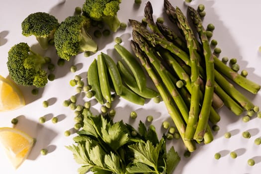 Overhead view of fresh raw green vegetables on white table. unaltered, food, healthy eating, organic concept.