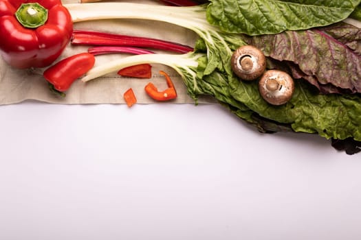 Directly above view of fresh chard with peppers and mushrooms by copy space on white background. unaltered, food, healthy eating, organic concept.