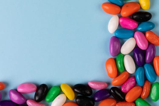 Overhead view of colorful candies and copy space on blue background. unaltered, sweet food and unhealthy eating concept.