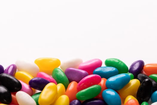 Close-up view of multi colored candies with copy space against white background. unaltered, sweet food and unhealthy eating concept.