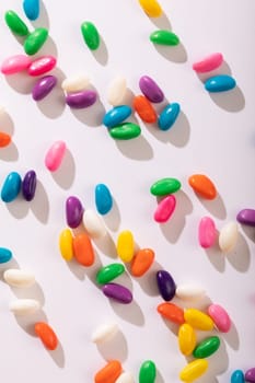 Directly above view of multi colored candies scattered against white background. unaltered, sweet food and unhealthy eating concept.