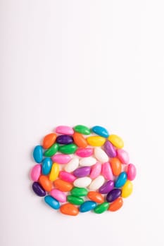 Directly above view of colorful candies arranged in circle with copy space against white background. unaltered, sweet food and unhealthy eating concept.