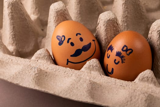 Close-up of creative drawing on brown eggs in carton. unaltered, food, healthy eating, creative, humor concept.