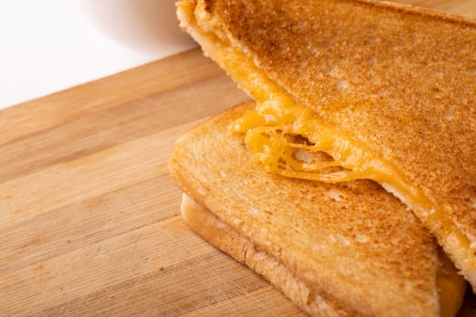 High angle view of fresh cheese sandwich served on brown wooden board. unaltered, food, unhealthy eating and snack concept.