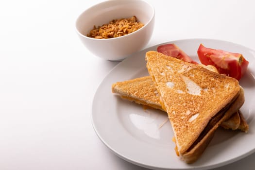 High angle view of cheese sandwich toast served with tomato slices in plate on white background. unaltered, food, unhealthy eating and snack concept.