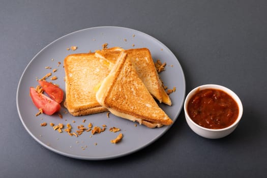 High angle view of fresh cheese toast sandwich served with tomato slices and dip on blue background. unaltered, food, unhealthy eating and snack concept.