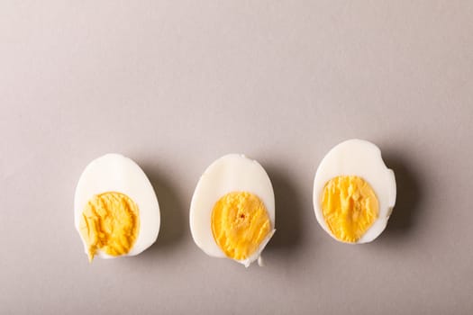 Directly above view of fresh boiled white egg halves against gray background with copy space. unaltered, food, healthy eating and organic concept.