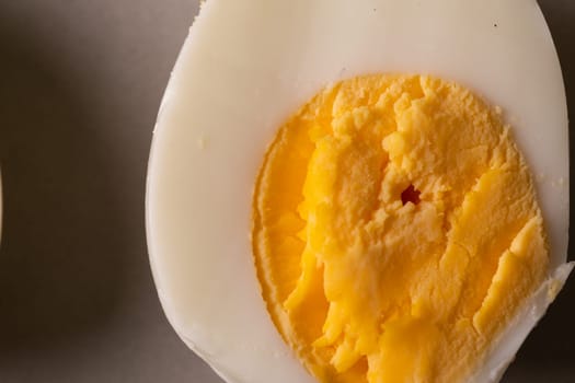Directly above close-up view of fresh boiled white egg with yellow yolk. unaltered, food, healthy eating and organic concept.
