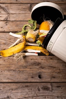 Directly above view of spilled organic waste in compost bin over wooden table. unaltered, decomposing, recycling, responsibility and environmental conversation concept.