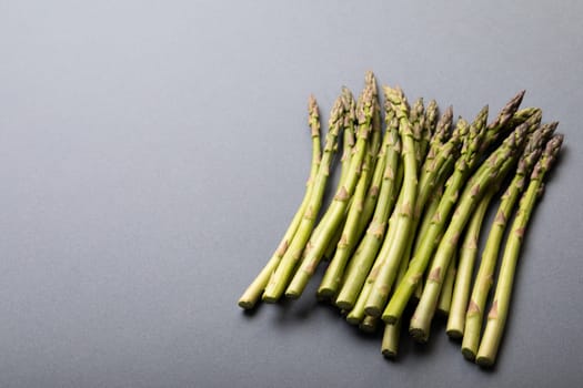 High angle view of fresh green asparagus on gray background with copy space. unaltered, food, healthy eating and organic concept.