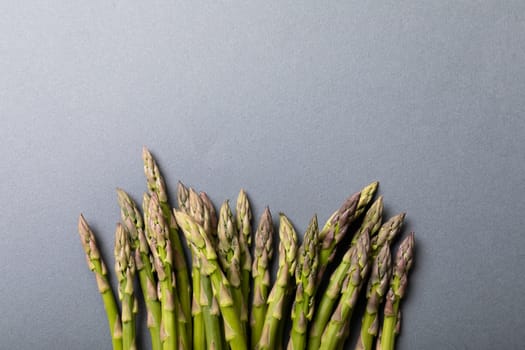 Directly above view of fresh green asparagus by copy space on gray background. unaltered, food, healthy eating and organic concept.