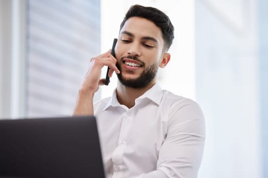 Phone call, laptop and businessman working in the office while talking on cellphone for communication. Happy, smile and professional male employee on mobile conversation while doing company research