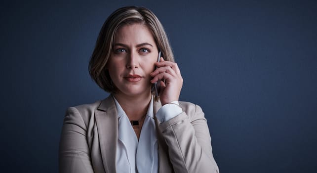 Im listening...Studio portrait of an attractive young corporate businesswoman making a call against a dark background