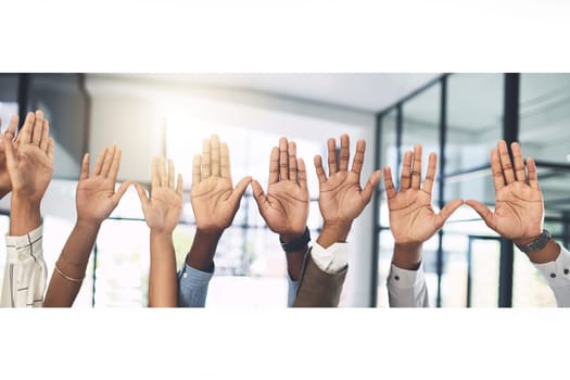 Have your voice heard. Closeup shot of a group of businesspeople raising their hands in an office