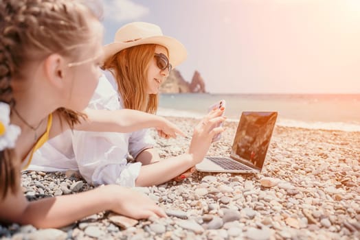 Woman sea laptop. Business woman in yellow hat working on laptop by sea. Close up on hands of pretty lady typing on computer outdoors summer day. Freelance, digital nomad, travel and holidays concept.