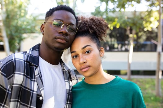 Portrait of African American young couple outdoors looking at camera with serious expression. Relationship concept.