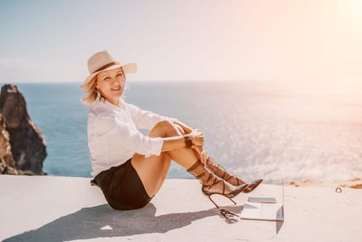 Happy girl doing yoga with laptop working at the beach. beautiful and calm business woman sitting with a laptop in a summer cafe in the lotus position meditating and relaxing. freelance girl remote work beach paradise