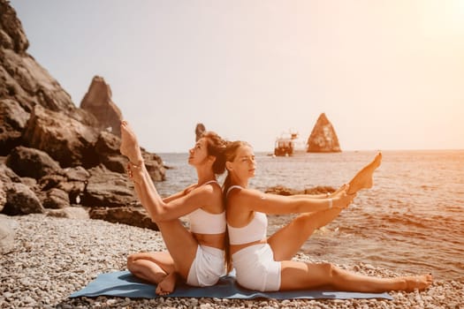 Woman sea yoga. Back view of free calm happy satisfied woman with long hair standing on top rock with yoga position against of sky by the sea. Healthy lifestyle outdoors in nature, fitness concept.