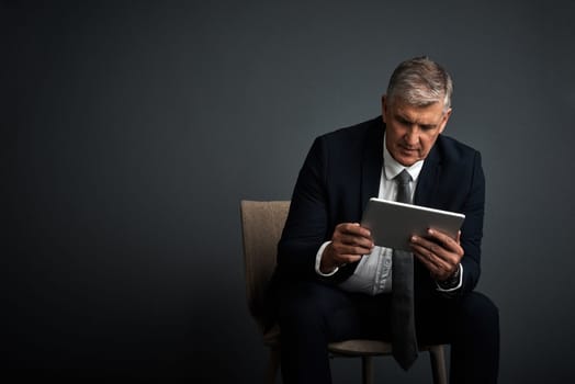 You create your own road map to success. Studio shot of a mature businessman using his digital tablet