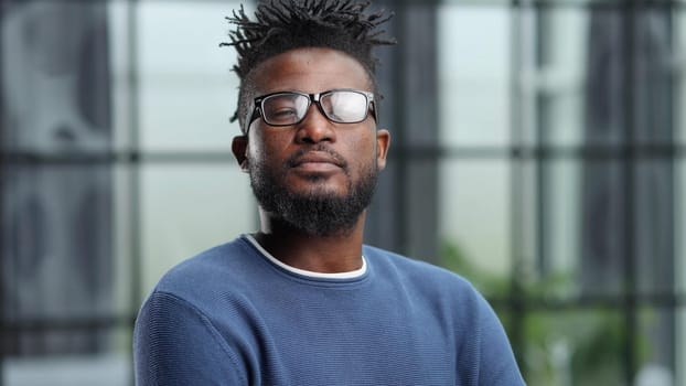 Portrait of a smiling CEO at workplace in a modern office in casual wear with glasses