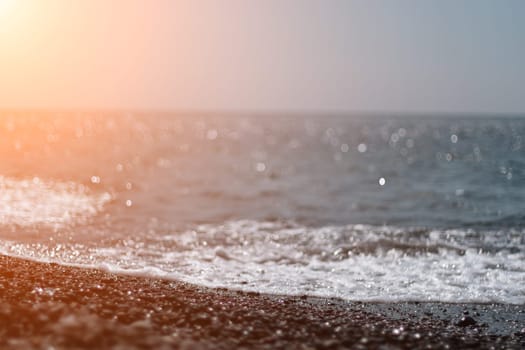 Abstract nature summer or spring ocean sea background. Small waves on water surface in motion blur with bokeh lights from sunrise.