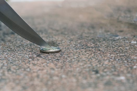 Knife blade on euro coin. Concept cutting rates, money business, crime. Macro, selective focus.