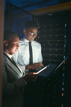 Comparing data on the latest programme. two young IT specialists standing in the server room and having a discussion while using a technology