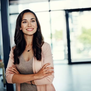 Nothing beats the feeling of achieving your biggest goals. a confident young businesswoman standing in an office