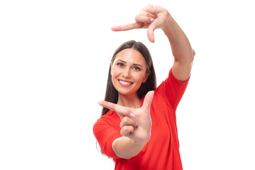 30 year old active Caucasian woman with straight dark hair dressed in red short sleeve shirt smiling on white background.