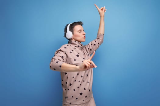 young looking business woman with gray streaked short hair with blues headphones dancing to the music.