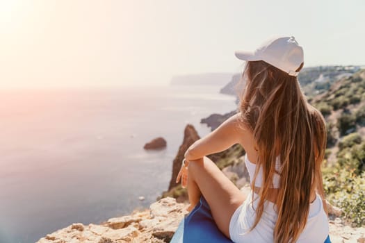 Woman meditating in yoga pose silhouette at the ocean, beach and rock mountains. Motivation and inspirational fit and exercising. Healthy lifestyle outdoors in nature, fitness concept.