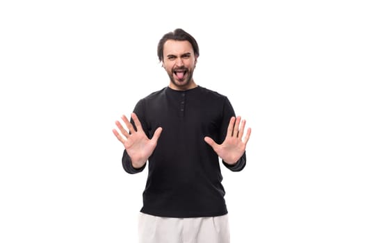 young confused handsome brunet european man in black sweatshirt on isolated white background.