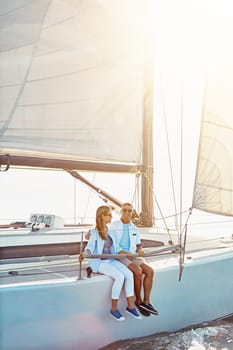 Couple, boat and adventure at sea for holiday during summer to relax on luxury or rich cruise. Ocean, vacation and people on yacht for outdoor travel and freedom to enjoy the sunshine together