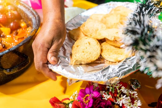 Closeup to the hands of an elderly Latin woman serving bread during Christmas dinner