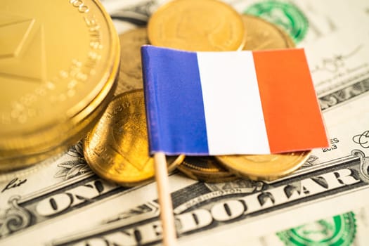 Stack of coins with France flag and US dollar banknotes.