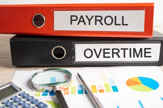 Payroll overtime. Binder data finance report business with graph analysis in office.