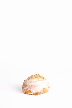 fresh bun with delicate cream and nuts on a white background.