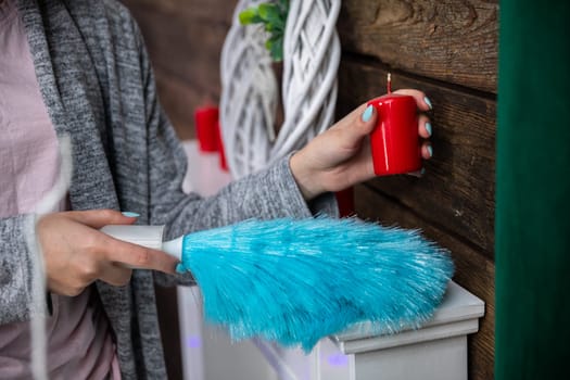 Under each object must be thoroughly cleaned to make the whole room sparkle for Christmas. The girl holds a red candle in her hand.