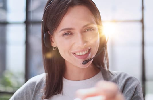 Smiling support phone woman operator in office. pointing at you