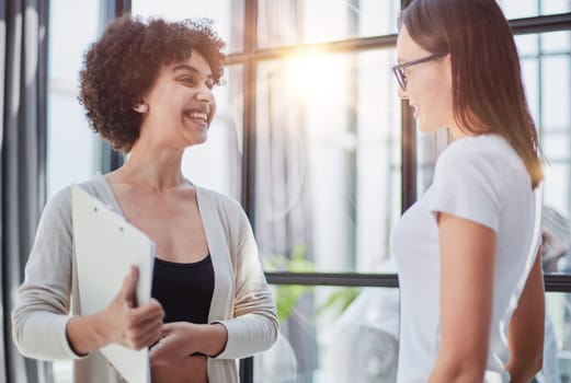Two middle age beautiful businesswomen smiling happy and confident working together. Shaking hands with smile on face for agreement at the office