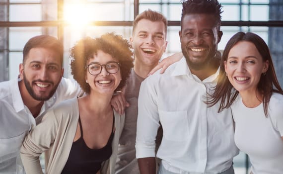Portrait of successful creative business team looking at camera and smiling. Diverse business people standing together at startup.