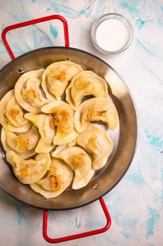 dumplings with potatoes in a frying pan top view.