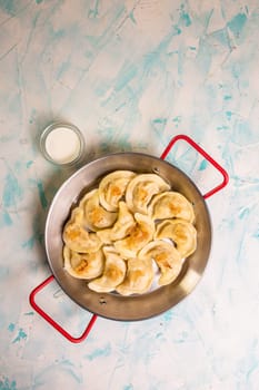 dumplings with potatoes in a frying pan top view.