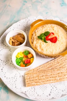 healthy breakfast with porridge top view. marmalade, porridge with butter and bread.