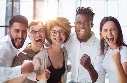Portrait of successful creative business team looking at camera and smiling. Diverse business people standing together at startup.