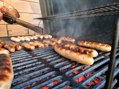 Delicious german sausages sizzling over the coals on barbecue grill