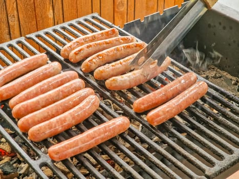 Delicious german sausages sizzling over the coals on barbecue grill