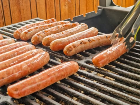 Delicious german sausages sizzling over the coals on barbecue grill